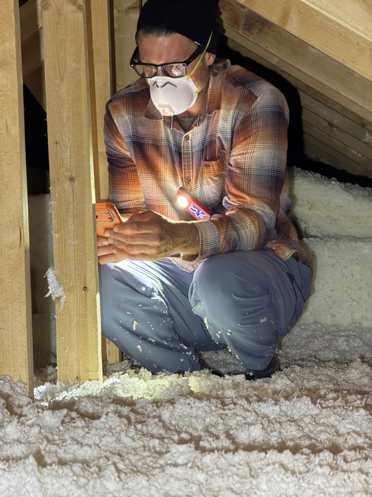 Inspector in a crawlspace wearing a Truestar shirt and Certified Master Inspector hat